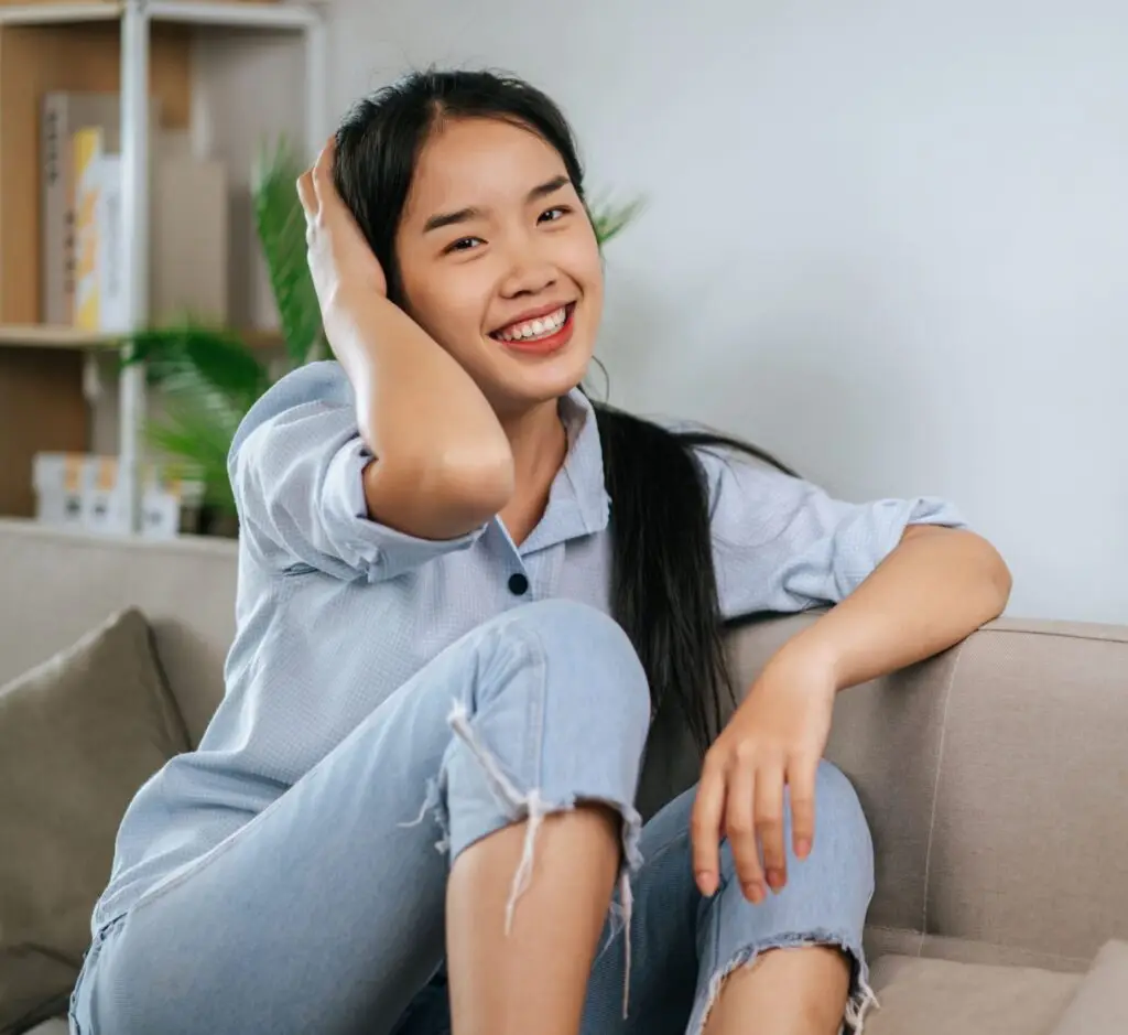 Young woman at home on the couch smiling