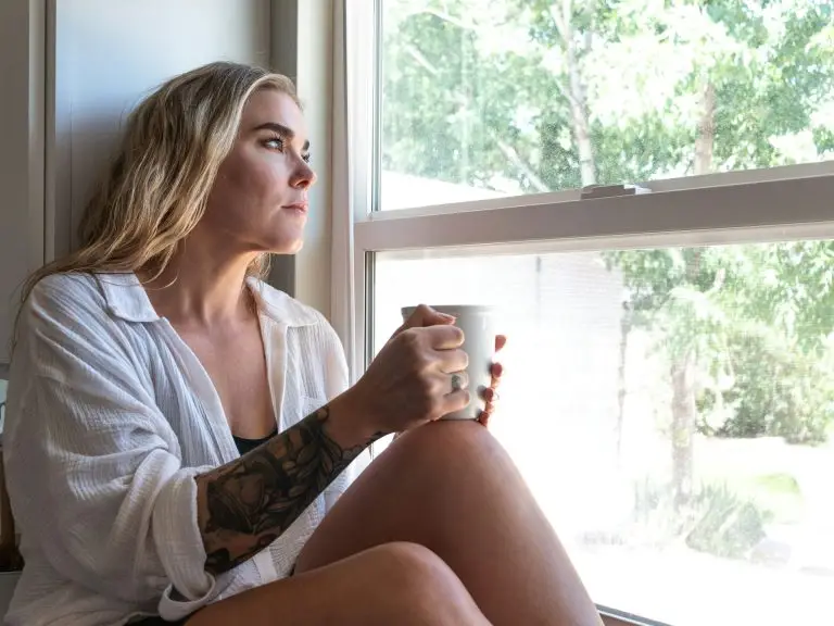 Adult sitting thoughtfully near window — emotionally immature parents and their impact on adult children